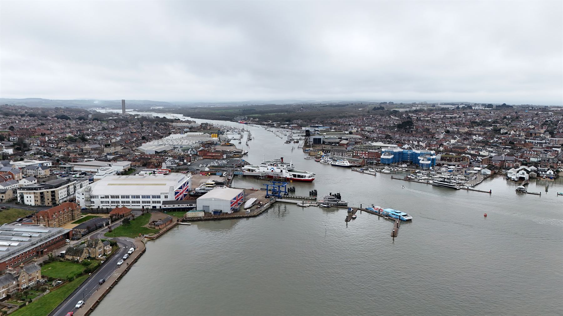 Aerial photograph along the River Medina at Cowes, showing the marina, boatyards, industrial units and the town beyond